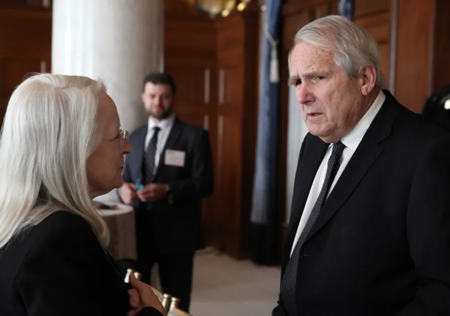 Two professionals conversing in formal setting indoors