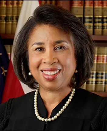 African American female judge smiling in courtroom setting