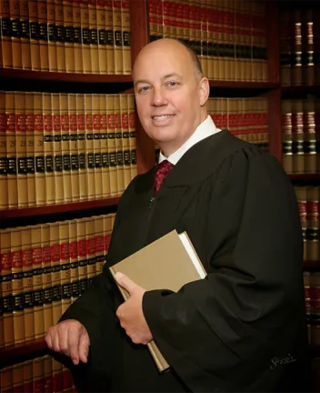 Judge in robes holding book in law library